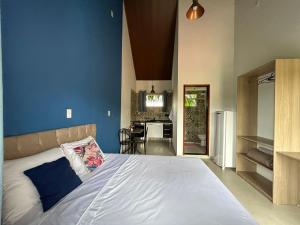 una camera da letto con un letto grande con una parete blu di Flats 2 Locação Penedo RJ a Penedo