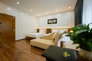 una habitación de hotel con dos camas y un sofá en AZOMA hotel, en Hanói