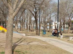 dos personas sentadas en un banco en un parque en Edificio Discus, en Villa María