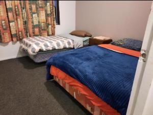 two beds in a small room with at Private Rooms at Bayfair in Tauranga