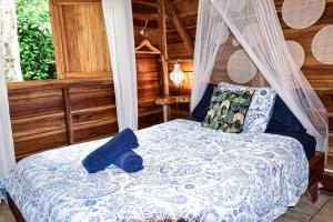 ein Schlafzimmer mit einem Bett, auf dem ein Teddybär liegt in der Unterkunft Up! House ~ Charming and cozy ~ 4 guests in Playa Chiquita in Cocles