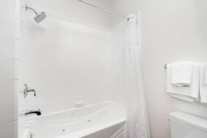 a white bathroom with a shower and a bath tub at Stonehouse Inn, Santa Rosa - Private King Suite # 3 in Santa Rosa +34 photos
