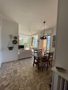 a dining room with a table and chairs and a kitchen at Panoramico Appartamento Fronte Lago in Griante Cadenabbia