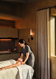 a woman standing next to a man on a bed at Stanly Ranch, Auberge Collection in Napa