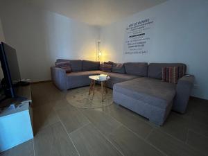 a living room with a couch and a table at La belle vie F4 bord de plage avec jardin in Calcatoggio +41 photos