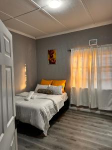 a bedroom with a bed and a window at Mila Lodge 2 in Goodwood