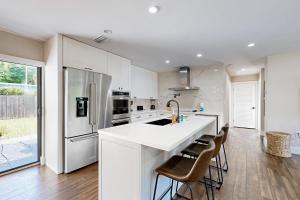Una cocina con encimera blanca y refrigerador. en Mid-Century Modern Oasis, en Miami