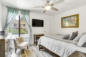 a bedroom with a bed with a ceiling fan and a window at Oceanside Condo with Pool and Hot Tub Access! in Oceanside +19 photos