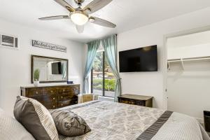 a bedroom with a bed and a tv and a window at Oceanside Condo with Pool and Hot Tub Access! in Oceanside
