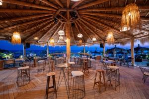 a restaurant with a large wooden ceiling and stools at Domi Drymades in Dhërmi