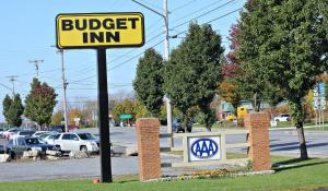 una señal para una posada de hamburguesas en un estacionamiento en Budget Inn - Farmington, en Farmington