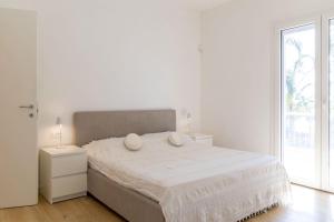 a white bedroom with a large bed with two pillows on it at Casa cancello a mare in Santa Flavia