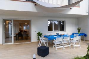 a dining room with a blue table and white chairs at Casa cancello a mare in Santa Flavia