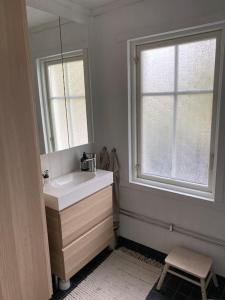 Un baño con lavabo, espejo y ventana. en Mysigt hus nära hav och skog på härliga Alnö, en Släda
