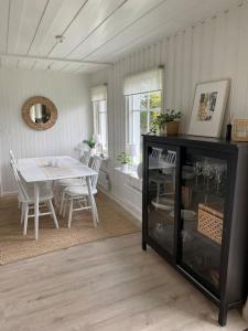 comedor con mesa, mesa y sillas en Mysigt hus nära hav och skog på härliga Alnö, en Släda