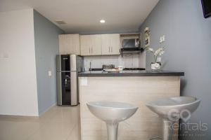 una cucina con 2 sedie bianche e un frigorifero di Mountain and City Views Loft Ultra-Fast Internet a Medellín Altre 10 foto