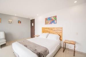 una camera da letto con un grande letto bianco in una stanza di Mountain and City Views Loft Ultra-Fast Internet a Medellín