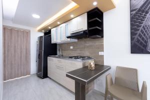 a kitchen with a black refrigerator and a table at Refugio Moderno para descansar en Santa Rosa in Santa Rosa de Cabal