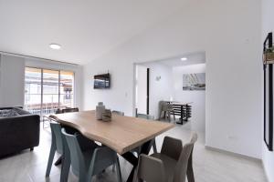 a dining room and living room with a wooden table and chairs at Refugio Moderno para descansar en Santa Rosa in Santa Rosa de Cabal