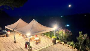 a tent with tables and chairs on a patio at night at Villa Marina in Chianciano Terme