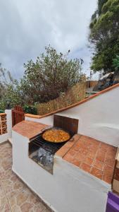 a pizza is cooking on a grill on a patio at Los Cerrajones: spectacular views from the cliff in Agulo