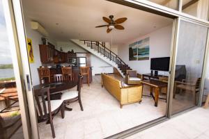 a living room and dining room with a ceiling fan at Ocean and Mountain View Villa in Playa Hermosa