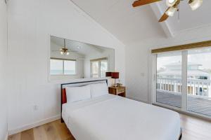 a white bedroom with a bed and a window at Hawkins Lookout in Cudjoe Key +18 photos
