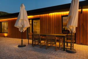 two white umbrellas sitting in front of a building at TerraSena Mountain Village - Serra da Estrela in Seia +166 photos