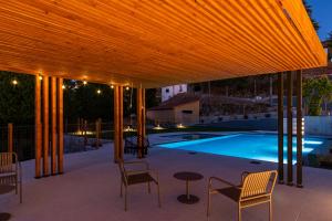 a pavilion with chairs and a table next to a swimming pool at TerraSena Mountain Village - Serra da Estrela in Seia
