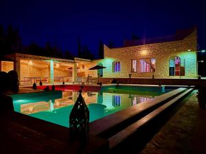 a house with a swimming pool at night at QUIET OASIS Luxury Stone Villa with Panoramic Views near Essaouira in Essaouira