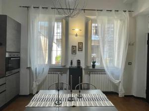 una cucina con tavolo e due finestre di Casa Giulia di Barolo a Torino