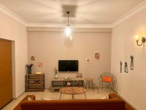 a living room with a tv and a table at Lavender Homes, Walled City in Famagusta