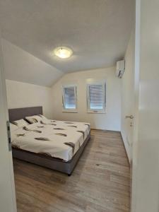 Un dormitorio con una cama y dos ventanas. en Villa Srebrena, en Sarajevo