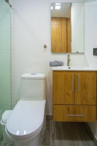 een badkamer met een toilet, een wastafel en een spiegel bij 301 Norte cali - The view in Cali +23 foto's
