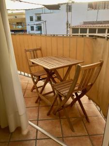 a wooden table and two chairs on a balcony at EL PATIO De Arguineguìn in Arguineguín