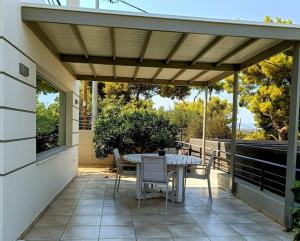 a patio with a table and chairs under a pergola at Porto SkyLine in Porto Rafti