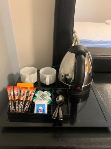 Příslušenství pro přípravu čaje a kávy v ubytování GO2 Gloucester Hotel by OYO