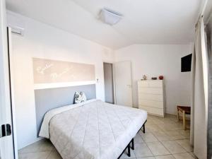 a white bedroom with a bed and a dresser at Ca' MaEle in Cattolica