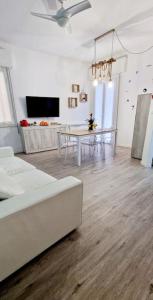 a white living room with a table and a couch at Ca' MaEle in Cattolica +5 photos
