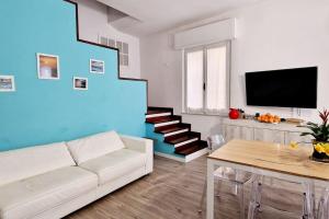 a living room with a white couch and a blue wall at Ca' MaEle in Cattolica