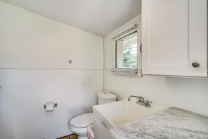 a white bathroom with a toilet and a sink at Walk to Buckingham Farms Peaceful Fort Myers Home in Fort Myers +18 photos