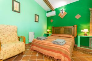 una camera verde con un letto e una sedia di Cortijo el Masegal, Carcabuey, centro de Andalucia a Carcabuey Altre 46 foto