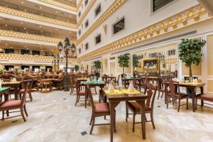 a restaurant with tables and chairs in a building at Habitat All Suites, Al Khobar in Al Khobar