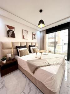 a large white bedroom with a large bed and a window at Loft de Luxe au Cœur de Rabat in Rabat