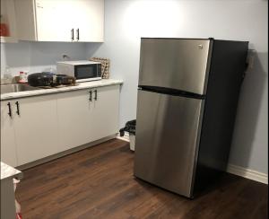 a kitchen with a refrigerator and a microwave at SHAY-BASEMENT-Holiday Home in Pickering