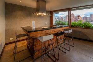 a kitchen with a bar with stools and a large window at The Charlee Hotel in Medellín +32 photos