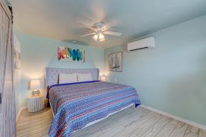 a bedroom with a bed and a ceiling fan at Casa Mariposa SPV19 in Port Aransas