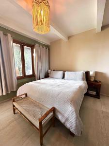 a bedroom with a large bed and a chandelier at Villa Perla A Surfer's Dream in Playa Venao +10 photos
