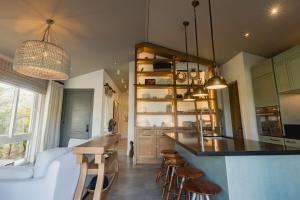 una cucina con bancone e alcuni sgabelli in una stanza di Villa Ceviche Home at the Heart of Venao a Playa Venao