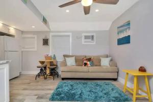 ein Wohnzimmer mit Sofa und Tisch in der Unterkunft Coastal Cottage - Just 7 Minutes to the Beach and Downtown! in Lake Worth